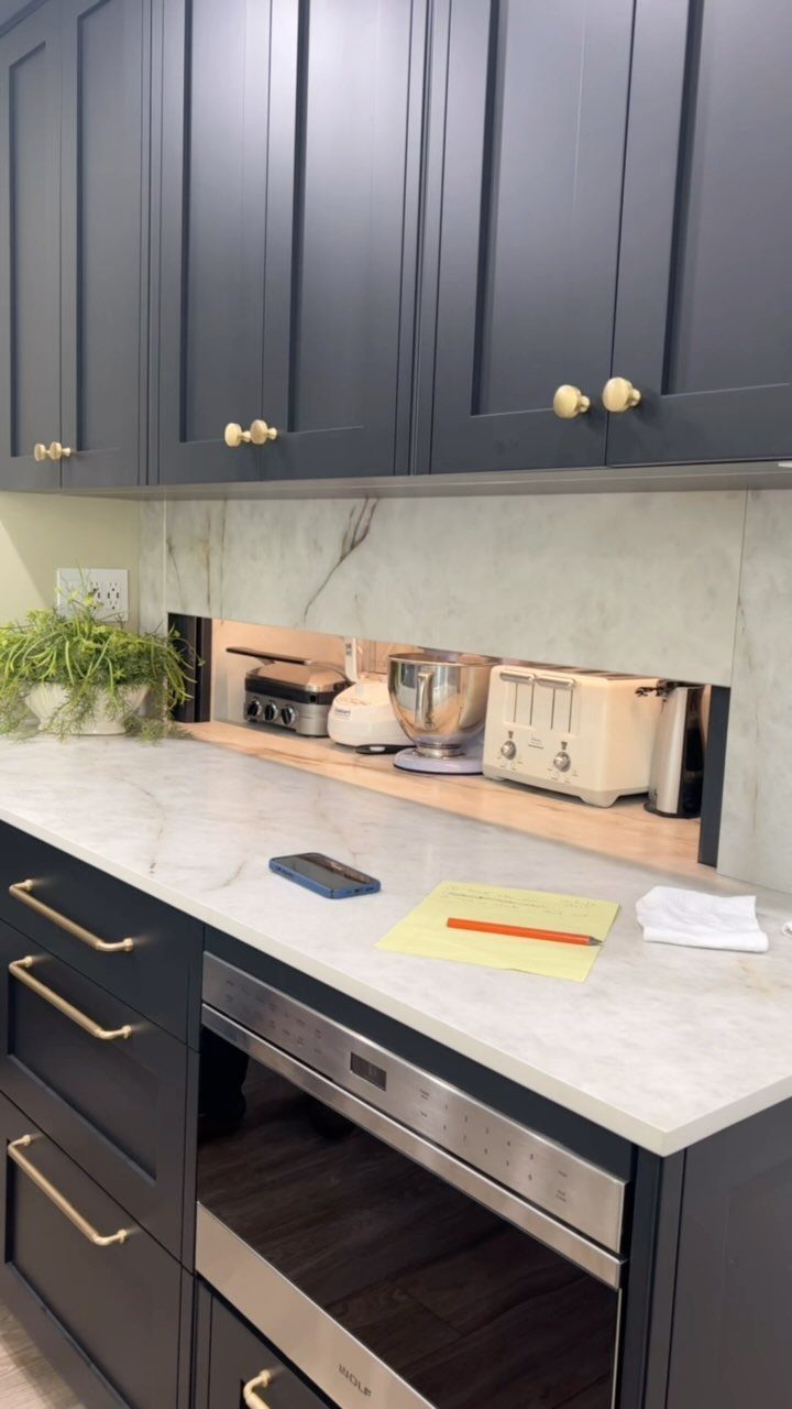 24 Small Kitchen Ideas 2026 for Storage, Style and Layout 9 Recessed appliance garage with small kitchen appliances under dark grey cabinets and marble countertop.