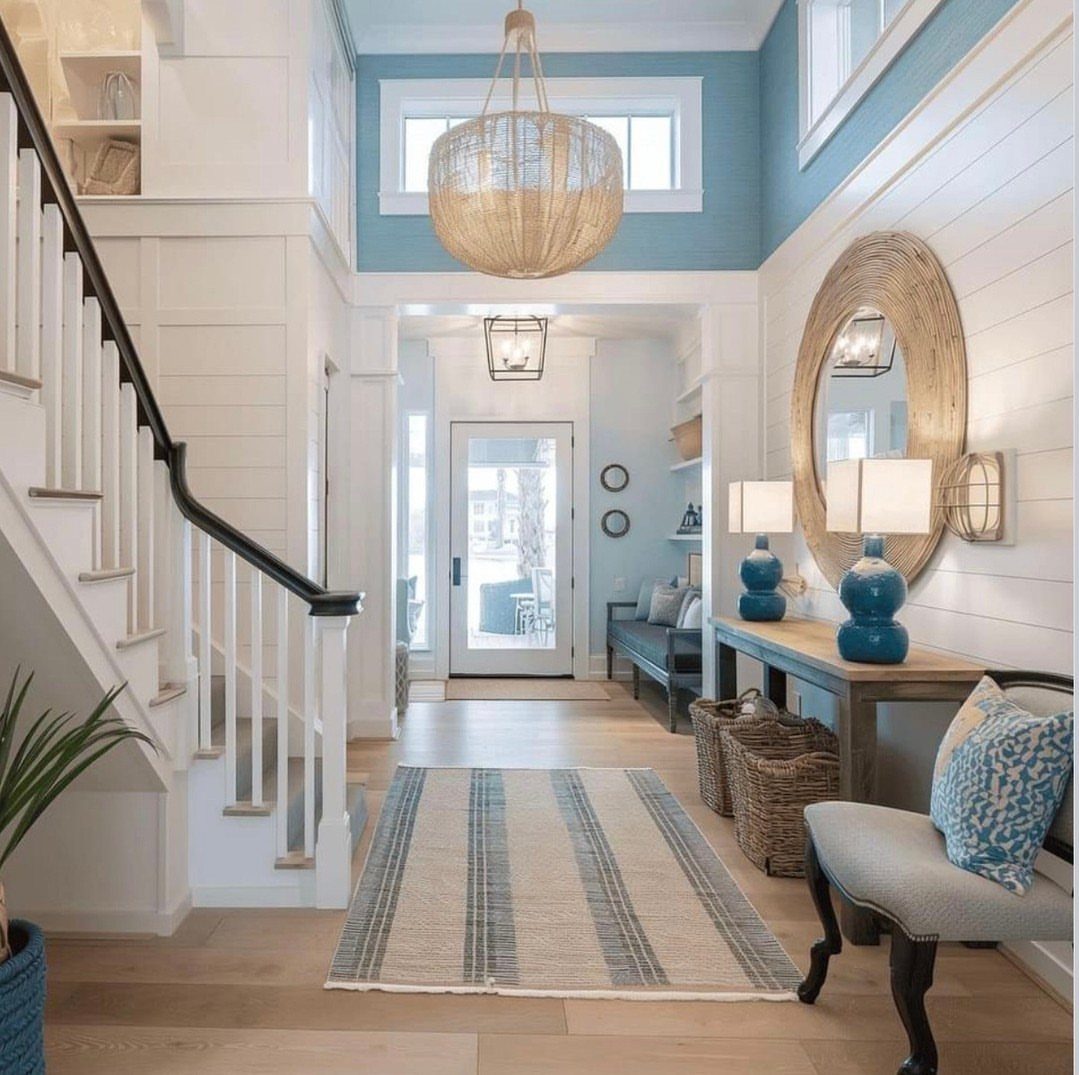 Bright entryway with a light blue upper wall, rattan pendant, and blue accents.