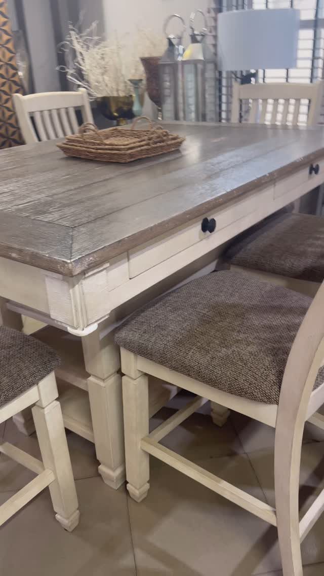 Rectangular dining table with grey top and cream base with storage drawer and chairs.