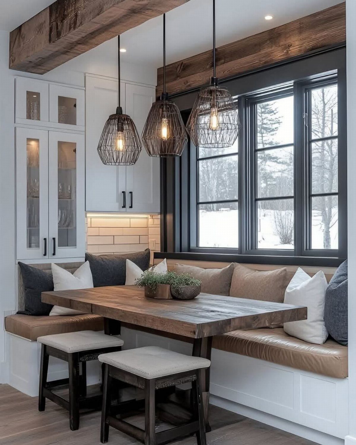 33 Kitchen Setting Ideas with Islands, Lighting, and Storage 9 Wooden dining table with leather banquette seating and pendant lights by a window.