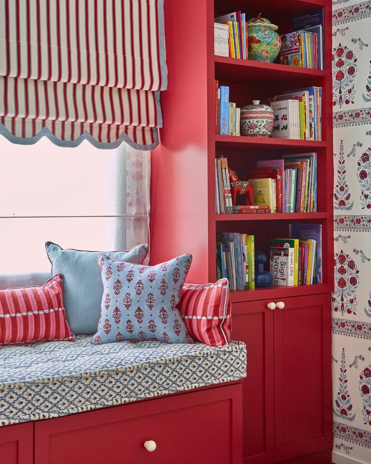 Girls Bedroom 10 12: 14 Ideas for Stylish Tween Rooms 10 Red window seat with pillows and adjacent red bookshelf filled with colorful books.