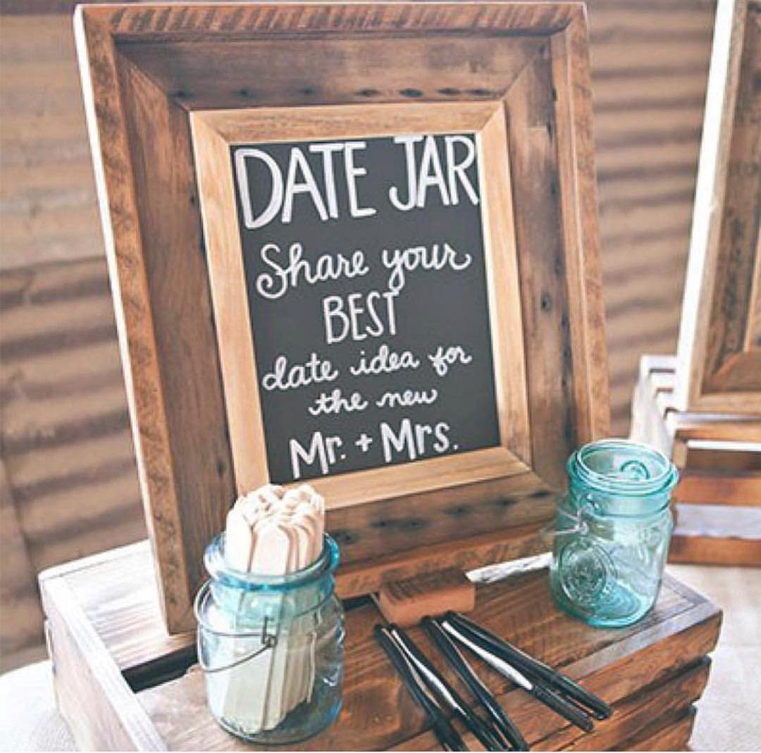 28 Wedding Decorations Ideas at Home with Flowers and Lights 27 Date jar setup with a chalkboard sign, popsicle sticks, and blue glass jars.