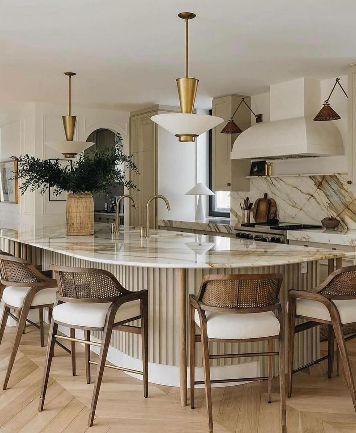 Kitchen Island with Seating on Two Sides: 10 Layout Ideas 8 Curved white kitchen island with marble top and four wooden cane-back bar stools.
