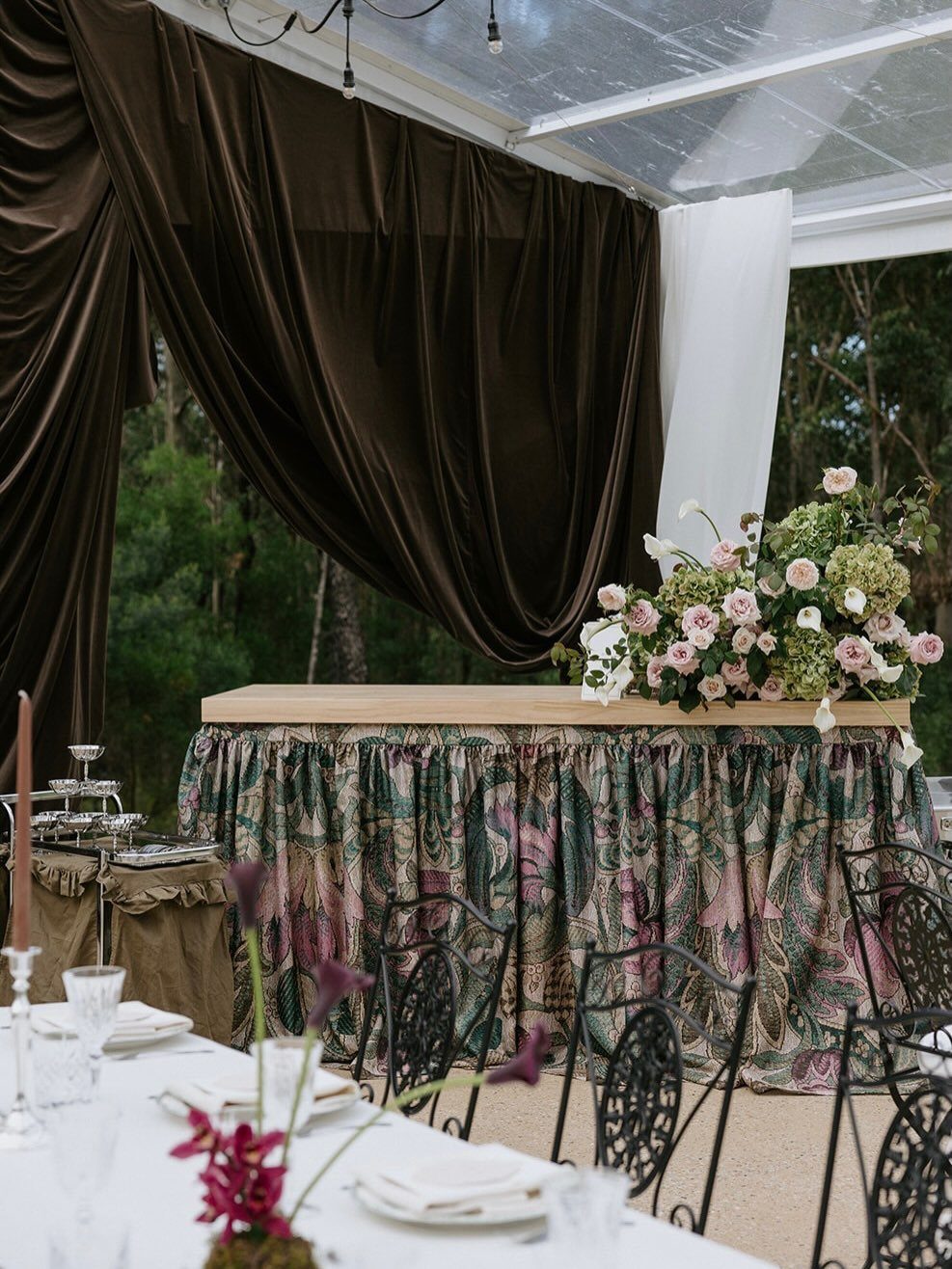 Movable Bar Counter Ideas: 8 Portable, Rolling and Home Styles 5 Wooden bar counter with floral arrangement and patterned fabric skirt under a tent