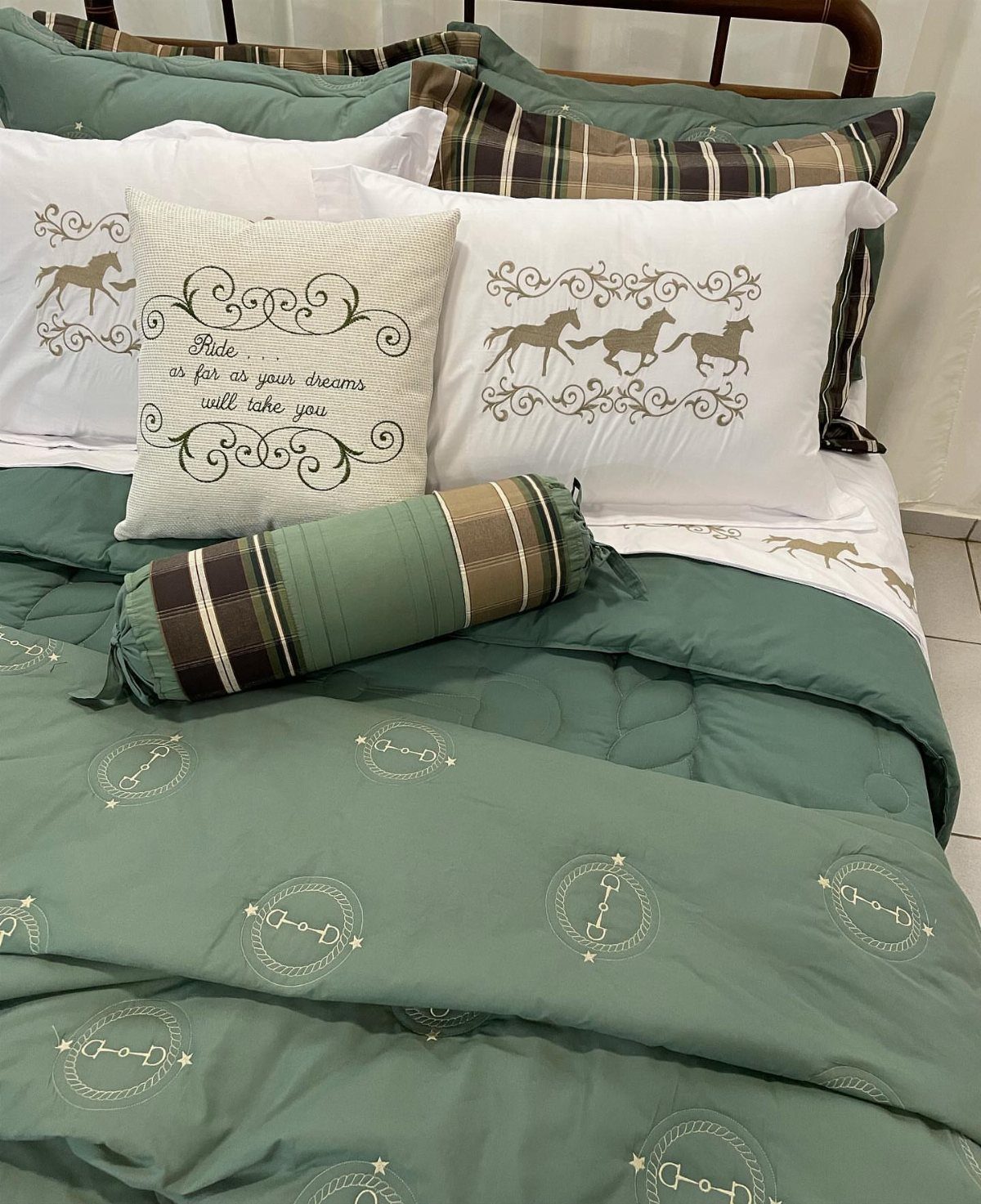 Horse-themed bedding in sage green and white with horse silhouettes and horseshoe patterns.