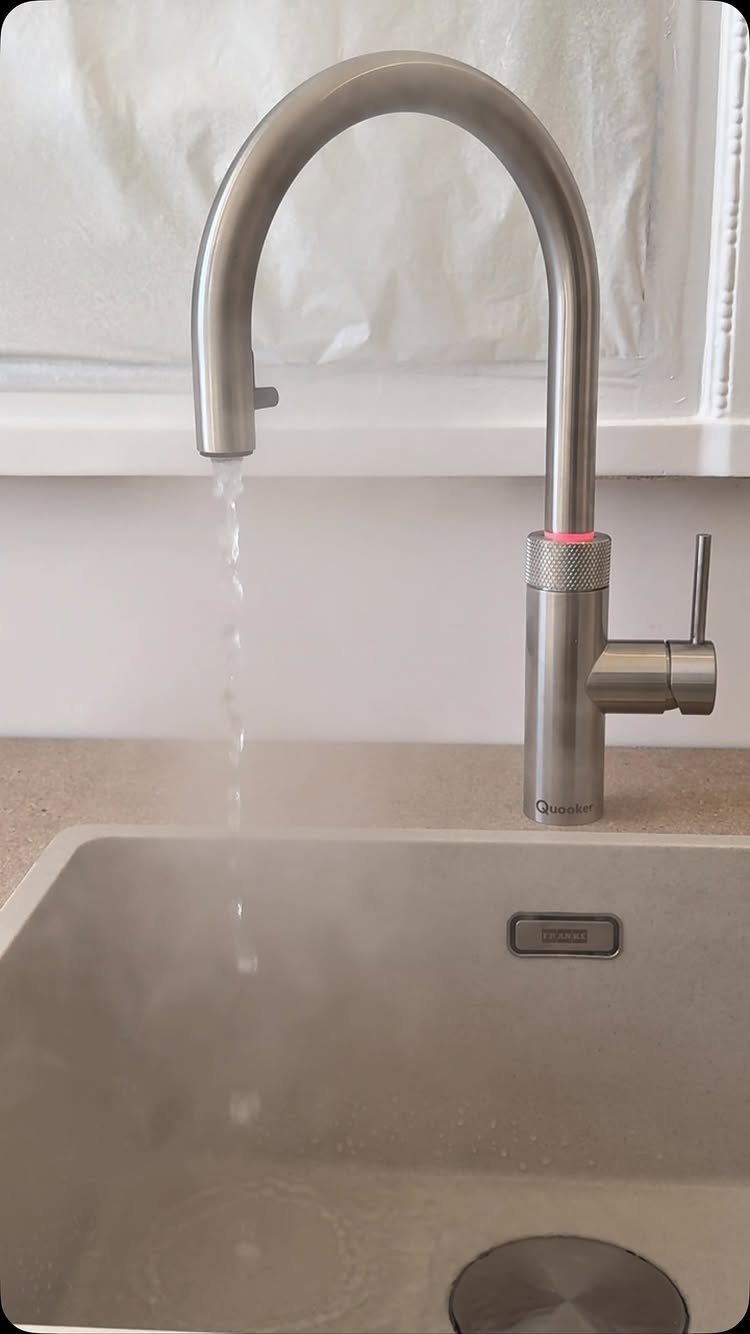 40 Small Kitchen Setup Ideas for Layouts, Storage and Style 17 Stainless steel gooseneck tap pouring steaming hot water into a kitchen sink