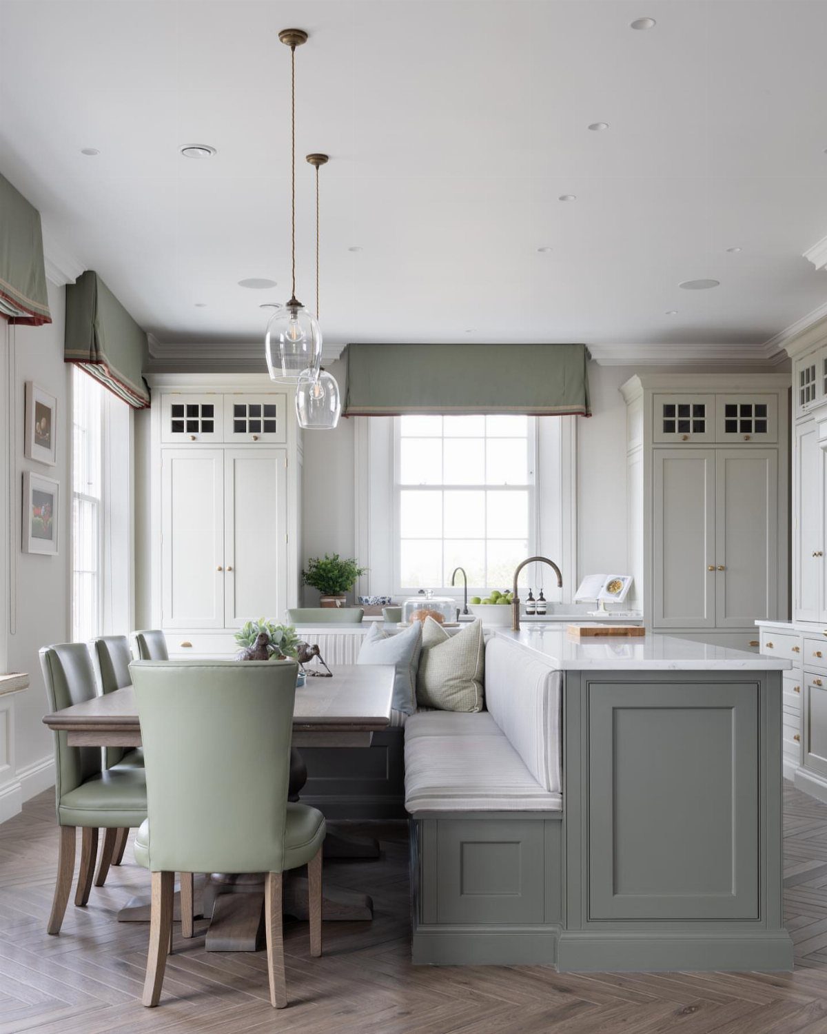 Kitchen Island with Seating on Two Sides: 10 Layout Ideas 5 Grey kitchen island peninsula with a built-in banquette and green upholstered dining chairs.