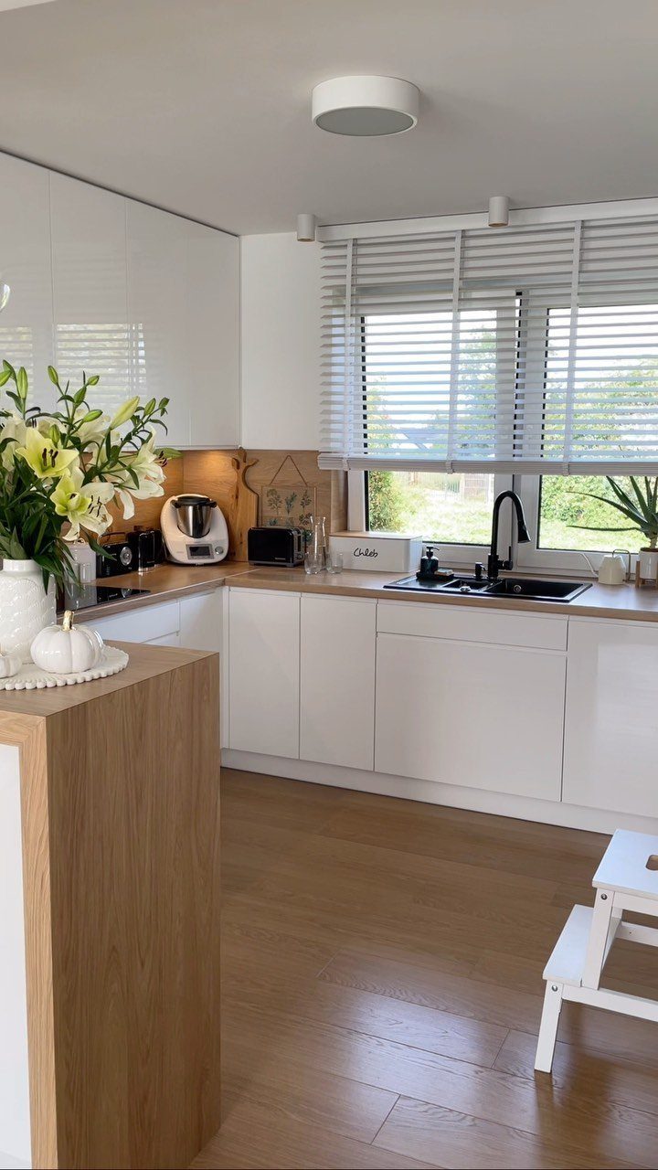 40 Small Kitchen Setup Ideas for Layouts, Storage and Style 3 White gloss kitchen cabinets and light wood countertops in a bright, small kitchen.