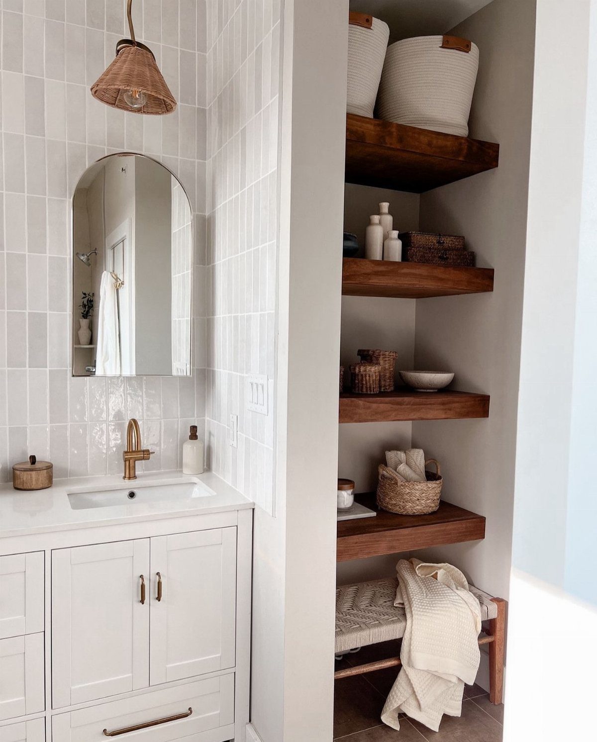 28 Bathroom Cabinet Ideas Storage Fixes for Small Spaces 10 White bathroom vanity with closed cabinets next to open wooden floating shelves with baskets.