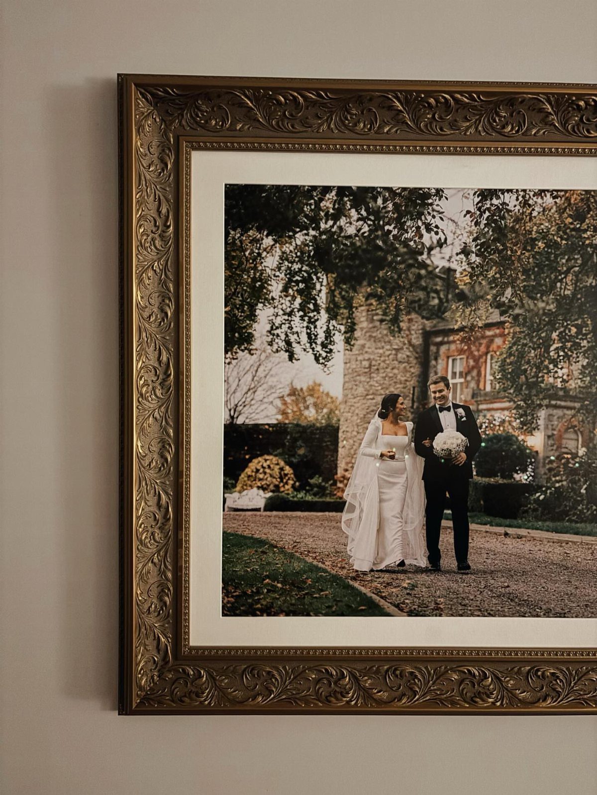 Ornate gold frame displaying a wedding photo of a couple on a wall