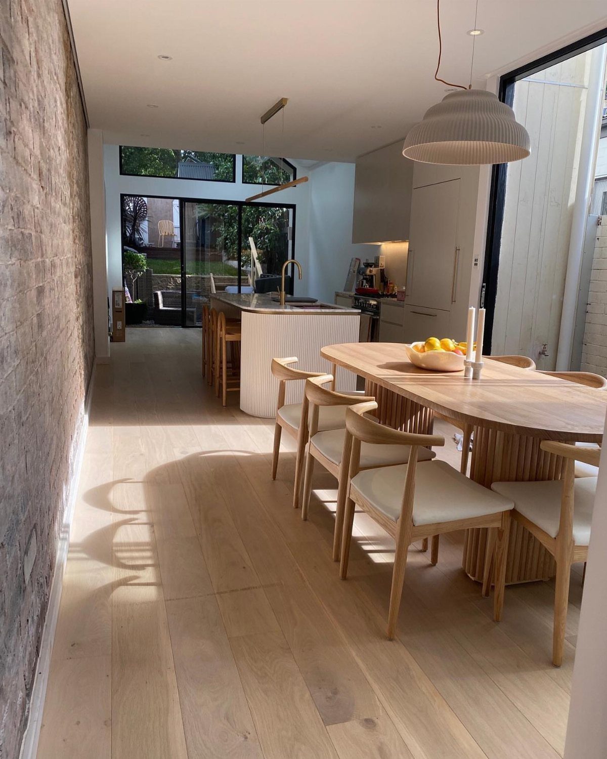 11 Kitchen Breakfast Table Ideas for Small and Roomy Kitchens 12 Oval wooden dining table with matching chairs in a bright modern kitchen setting
