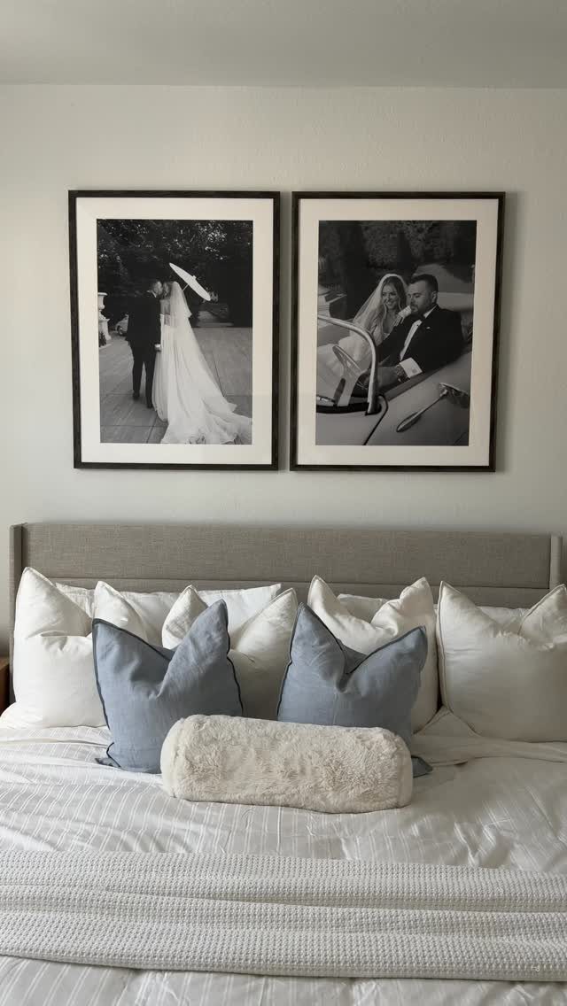Two black and white wedding photos framed on a wall above a bed.