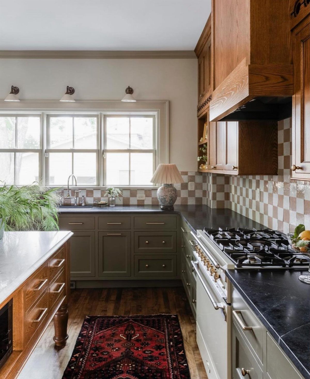 40 Small Kitchen Setup Ideas for Layouts, Storage and Style 35 Small kitchen with olive green cabinets, dark countertops, and a red patterned rug.