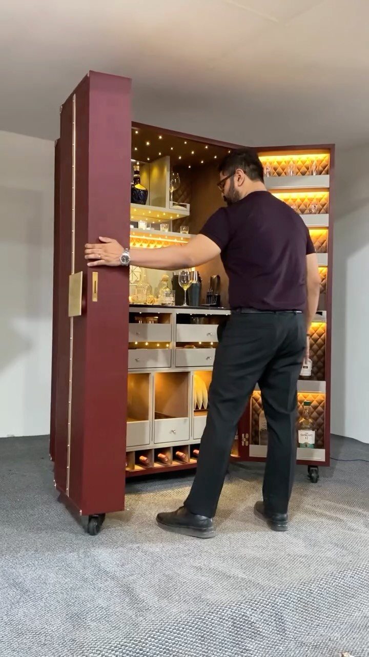 Movable Bar Counter Ideas: 8 Portable, Rolling and Home Styles 2 Burgundy portable bar on wheels with illuminated interior shelves and a man standing beside it.