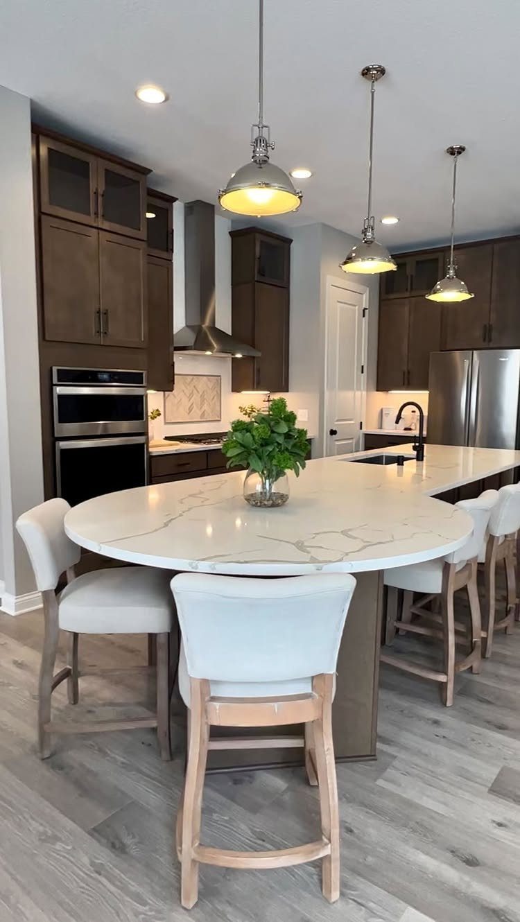 Kitchen Island with Seating on Two Sides: 10 Layout Ideas 11 White marble kitchen island with seating on two sides and white bar stools.
