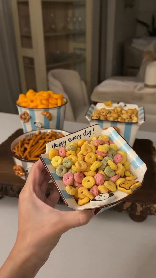 17 Kitchen Snack Storage Ideas for Pantries and Counters 10 Small striped bowls filled with colorful cereal and snacks on a wooden tray.