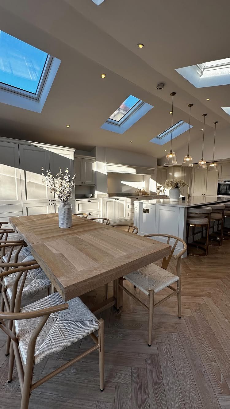 11 Kitchen Breakfast Table Ideas for Small and Roomy Kitchens 8 Solid wood rectangular dining table with woven chairs in a bright modern kitchen.