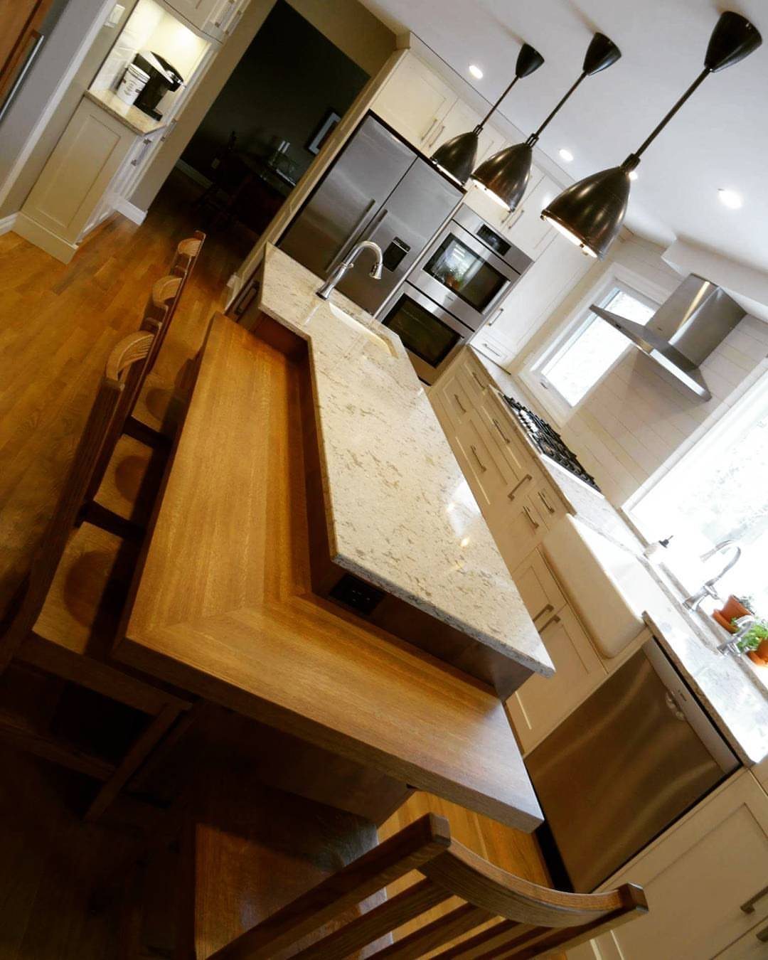 Kitchen Island with Seating on Two Sides: 10 Layout Ideas 3 Split-level kitchen island with a white marble prep surface and a lower wooden dining area.