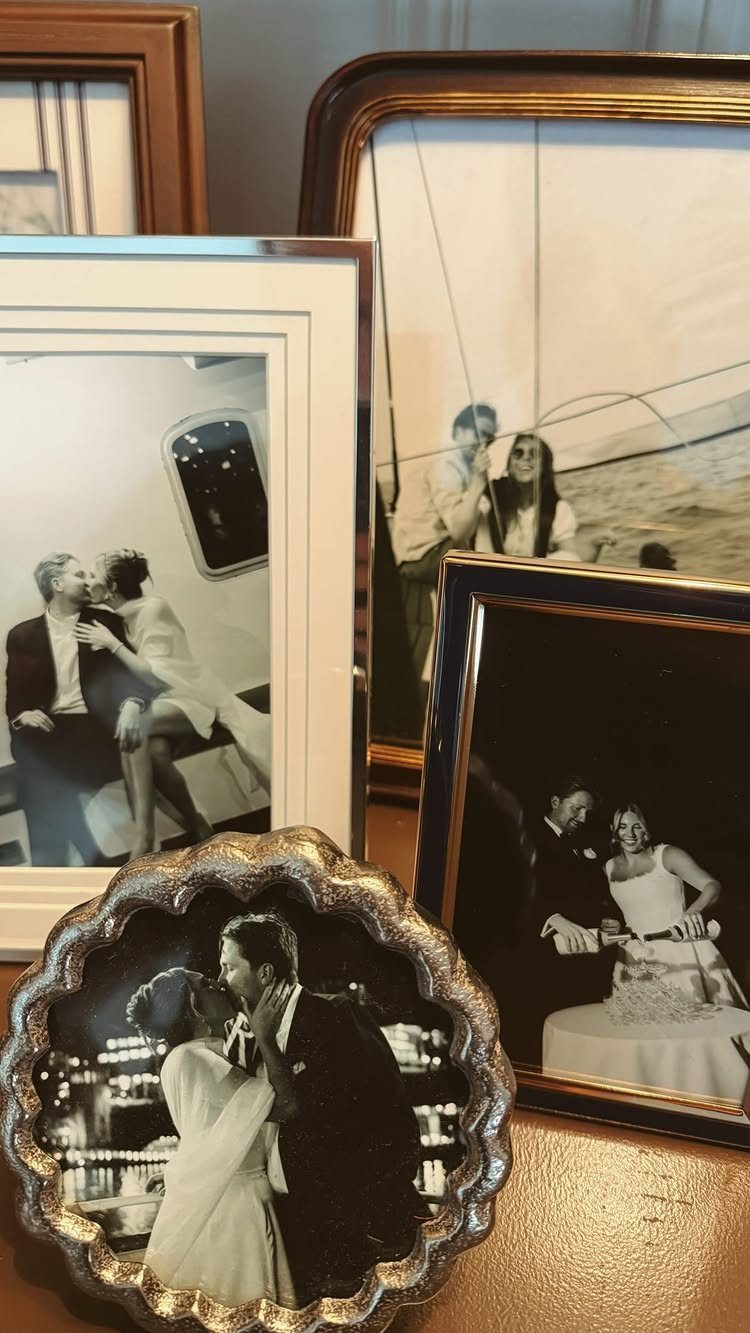 Framed wedding photographs of a couple displayed together on a wooden surface.