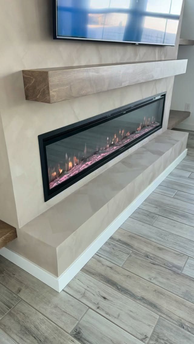 16 TV Designs for Living Room Walls, Units and Mounts 15 Wall-mounted television above a modern linear electric fireplace with a wooden mantel