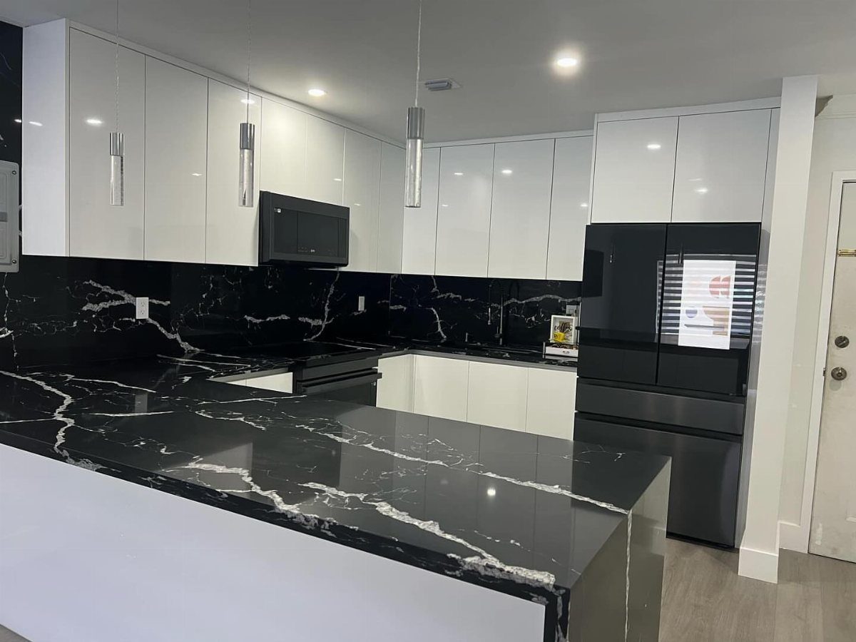 Black veined porcelain countertops and matching backsplash in a modern white kitchen